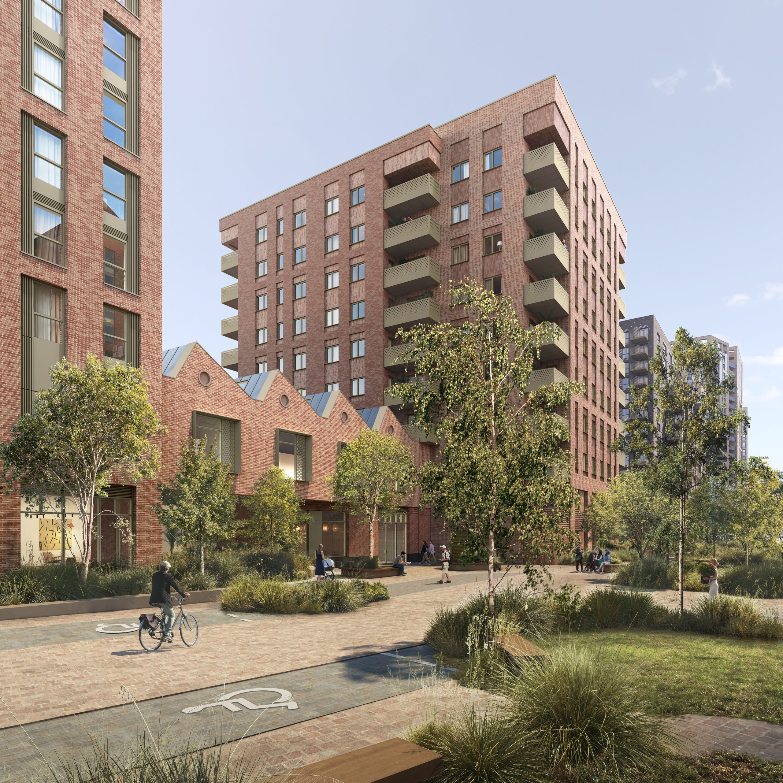 View towards the affordable apartment block beside the sawtooth-roofed workspace. Interlocking brick volumes and bronze-coloured balconies add depth, variation and visual interest.